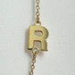 close up of gold initial R on a necklace